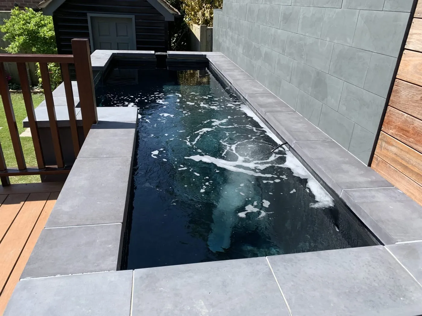 Black GRP fibreglass-lined plunge pool with grey stone surround